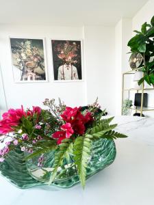 a vase filled with red flowers on a table at Luxury Belfast Stay in Belfast