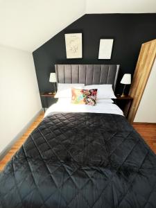 a bedroom with a large bed with a black headboard at Luxury Belfast Stay in Belfast