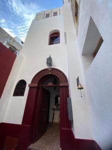um edifício branco com uma porta vermelha e branca em Riad Siham em El Jadida