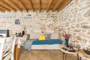 a bedroom with a bed in a stone wall at Holiday Home Vintage in Split