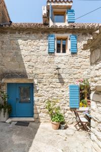 a stone building with a blue door and windows at Holiday Home Vintage in Split