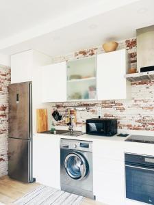 a kitchen with white cabinets and a washer and dryer at Apartamento Surfspot Las Palmas de Gran Canaria in Las Palmas de Gran Canaria