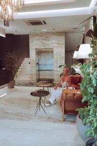 a woman sitting on a couch in a living room at Hotel Pasha in Mostar