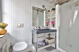 a bathroom with a sink and a toilet and a shower at 1 Bedroom Le Marais Temple in Paris