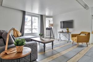 a living room with a couch and a table at 1 Bedroom Le Marais Temple in Paris