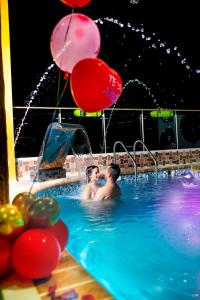 dos personas en una piscina con globos en La Floresta de Cite Hotel, en Cite