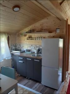 a kitchen with a white refrigerator in a cabin at Kremanski čardak in Kremna