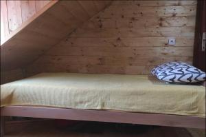 a bed in a room with a wooden wall at Kremanski čardak in Kremna