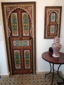 een houten deur met een tafel ervoor bij Riad Siham in El Jadida