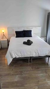 sypialnia z łóżkiem z białą pościelą i niebieskimi poduszkami w obiekcie Maison avec piscine, jacuzzi et sauna privatifs - Mas de Nebbas w Aix-en-Provence