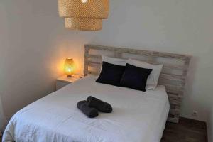 sypialnia z białym łóżkiem i 2 ręcznikami w obiekcie Maison avec piscine, jacuzzi et sauna privatifs - Mas de Nebbas w Aix-en-Provence