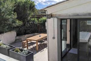 patio z drewnianym stołem i roślinami w obiekcie Maison avec piscine, jacuzzi et sauna privatifs - Mas de Nebbas w Aix-en-Provence