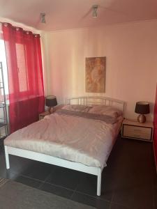 1 dormitorio con 1 cama con cortinas rojas en Apartament Robotnicza, en Sanok