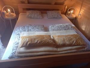two beds in a room with two tables at Planinska brvnara in Kupres