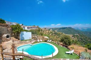 a swimming pool on top of a hill with mountains at Hotel Almejí in Benadalid