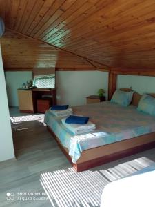 a bedroom with a large bed with a wooden ceiling at Summer SZ Guest House in Sozopol