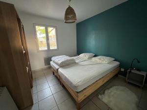 - une chambre avec un grand lit et un mur bleu dans l'établissement Villa Jungle house, à Alba-la-Romaine