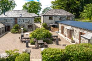 a group of buildings with benches in a courtyard at Ta Mill Cottages & Lodges - Pump Cottage in Launceston