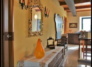 - un salon avec un miroir et un vase sur une table dans l'établissement Villa vacanze floriana, à SantʼAngelo in Lizzola