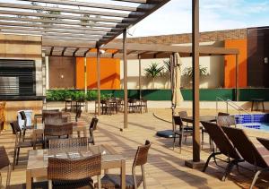 a patio with tables and chairs and a pool at Apto no Enjoy Olímpia Park Resort in Olímpia