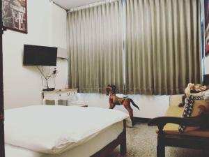 una camera con un letto e una statua di un cane di fronte a una finestra di DongNing Atlas Hotel a Tainan