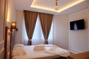 Amico Hotel في بريشتيني: غرفة فندق عليها سرير وفوط