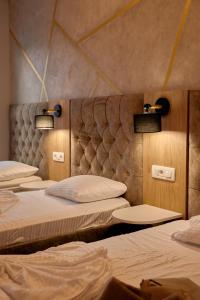 szereg łóżek w pokoju z oświetleniem w obiekcie Amico Hotel w Prisztinie