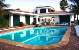 a swimming pool in front of a house at Los Fondos in Costa Del Silencio +21 photos