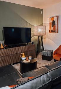 uma sala de estar com um sofá e uma televisão de ecrã plano em CASA GIABICONI - Villa 6pers. piscine & spa em Occhiatana