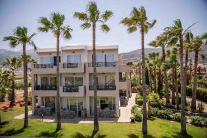 an exterior view of a building with palm trees at Aeolos Beach Resort in Malia