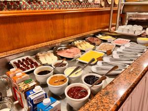 um buffet com muitos tipos diferentes de comida em um balcão em Hotel Bella Italia em Foz do Iguaçu