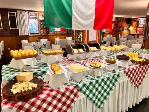 a table topped with lots of different types of food at Hotel Bella Italia in Foz do Iguaçu