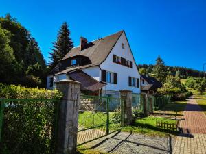 une maison blanche avec une clôture devant elle dans l'établissement Apartament Anielski E.D. Angelo, à Duszniki-Zdrój