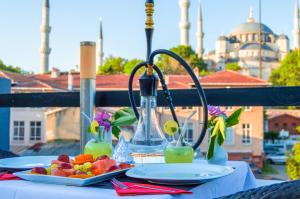 uma mesa com um prato de frutas e um liquidificador em Sarnic Hotel & Sarnic Premier Hotel(Ottoman Mansion) em Istambul