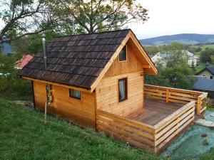 eine Blockhütte mit einer Terrasse und einem Dach in der Unterkunft Mała Aleksandra 