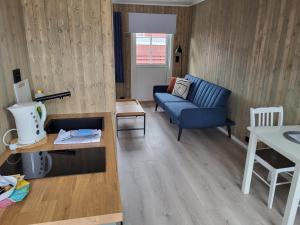 a living room with a blue couch and a table at Å Rorbuer - by Classic Norway Hotels in Å