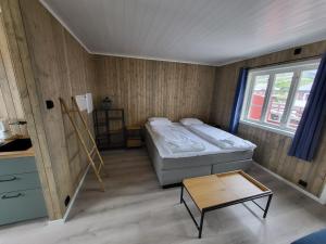 オーにあるÅ Rorbuer - by Classic Norway Hotelsのベッドとテーブル付きの小さな部屋