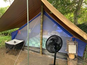 a tent with a fan and a table in it at Ginebra Glamping in Ginebra