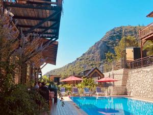 a pool at a resort with a mountain in the background at 7 Green Adrasan in Adrasan