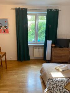 ワルシャワにあるNa Wspólnej Apartamentのベッドルーム1室(ベッド1台付)、窓(緑のカーテン付)