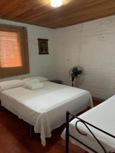 een slaapkamer met 2 bedden, een ventilator en een raam bij Ginebra Glamping in Ginebra
