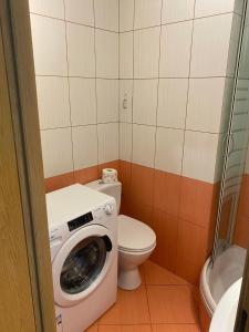 y baño con lavadora y aseo. en Na Wspólnej Apartament, en Varsovia