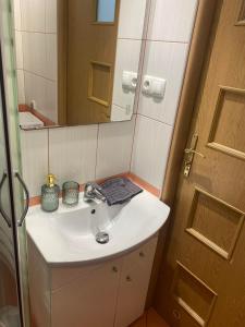 a bathroom with a white sink and a mirror at Na Wspólnej Apartament in Warsaw