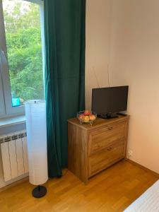 a bedroom with a television and a bowl of fruit on a dresser at Na Wspólnej Apartament in Warsaw +7 photos