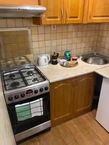 a kitchen with a stove and a sink at Na Wspólnej Apartament in Warsaw