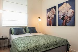 sypialnia z łóżkiem i dwoma obrazami na ścianie w obiekcie City Lux Apartment 2 - with garage and balcony w mieście Zadar