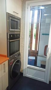 a kitchen with a microwave and a door to a balcony at Apartamento en San Sebastián con parking in Loyola