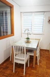 uma mesa de jantar branca e cadeiras com uma planta em Apartamento en San Sebastián con parking em Loyola