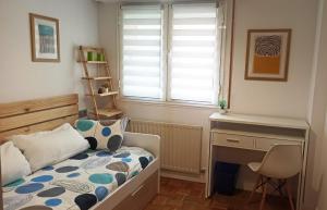 um quarto com uma cama, uma secretária e uma janela em Apartamento en San Sebastián con parking em Loyola
