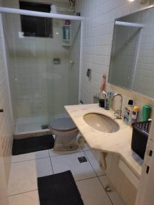 y baño con lavabo, ducha y aseo. en Apartamento Centro Cabo Frio, en Cabo Frío